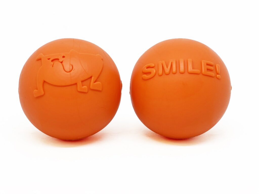 An image of SodaPup – True Dogs, LLC – SP TPE Smile Ball Medium – Bright Orange
